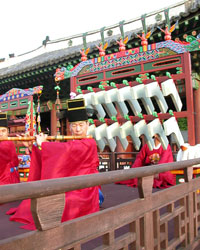 Joseon instruments once again resonate within palace walls. A court musician blows into his daegeum as the pyeongyeong player behind waits for his chance to chime in.