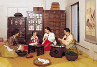 A family making songpyeon, half moon-shaped rice cakes, for Chuseok