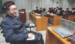 Professor Lee delivers a lecture by operating a bottlelike computer mouse.