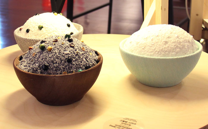 The exhibit shows a table with various overflowing rice bowls. Exhibit organizer said, 'overflowing rice bowls embody traditional food culture, showing how people have been consuming rice as their main staple and how it creates a warm emotional bond.' 