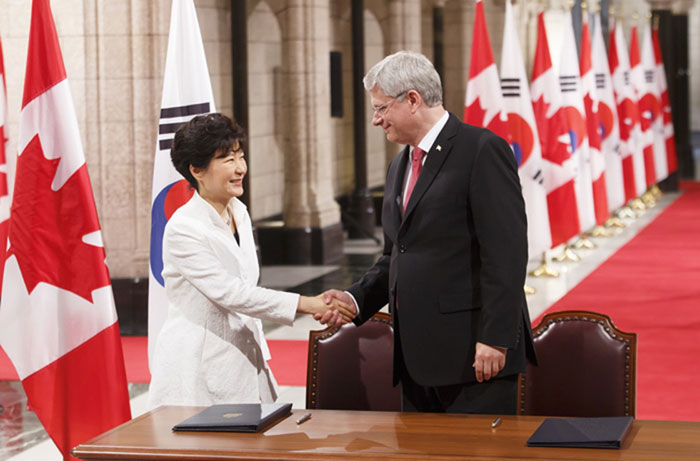 President Park Geun-hye (left) and Canadian Prime Minister Stephen Harper shake hands after signing the Korea-Canada FTA in the Hall of Honour at Parliament Hill in Ottawa.