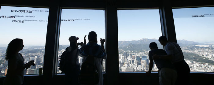 Visitors to the Seoul N Tower look out the window onto Seoul’s cityscape. (photo: Yonhap News)