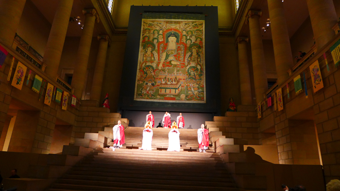 A group of Korean monks perform the ritual installation of a gigantic portrait of the Buddha, on loan from Hwaeomsa Temple in Gurye, Jeollanam-do (South Jeolla Province). This ritual, the Yeongsanjae ritual, is on the list of Korean UNESCO Intangible Cultural Heritage items.