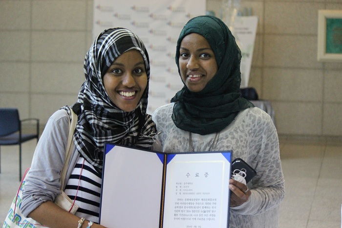 Two sisters from Ethiopia smile as they hold up their completion certificates from the speech competition. (photo: Wi Tack-whan) 