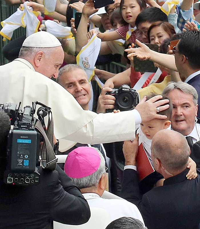 Pope Francis enters the Daejeon World Cup Stadium on August 15 to celebrate a Mass on the Solemnity of the Assumption. On the way, he stopped his car several times to greet some of the younger attendees.