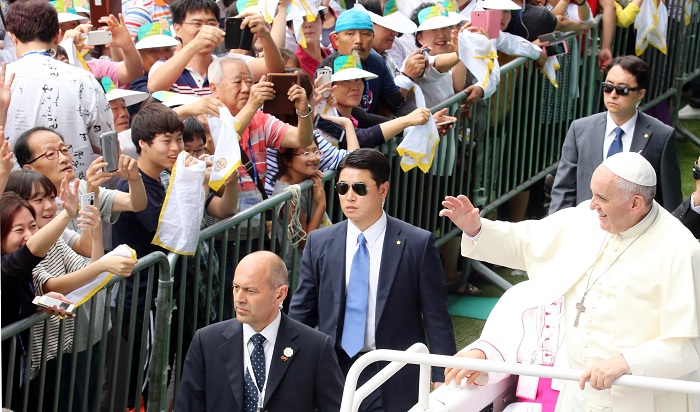 프란치스코 교황이 15일 성모승천대축일 미사 집전을 위해 대전월드컵경기장을 들어서고 있다. 교황은 입장 도중 여러 차례 차를 세워 어린 아이의 머리를 쓰다듬어 주었다.