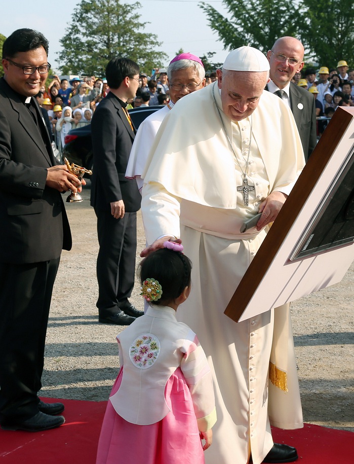 Pope Francis blesses a little girl after he fills out the guestbook at the Solmoe Sanctuary. 