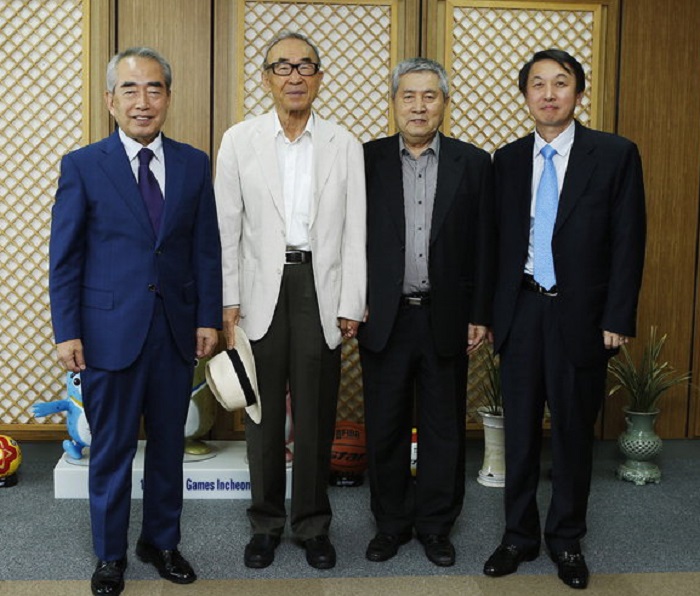 Poet Ko Un (second from left) poses for a photograph with members of the Olympic organizing committee.