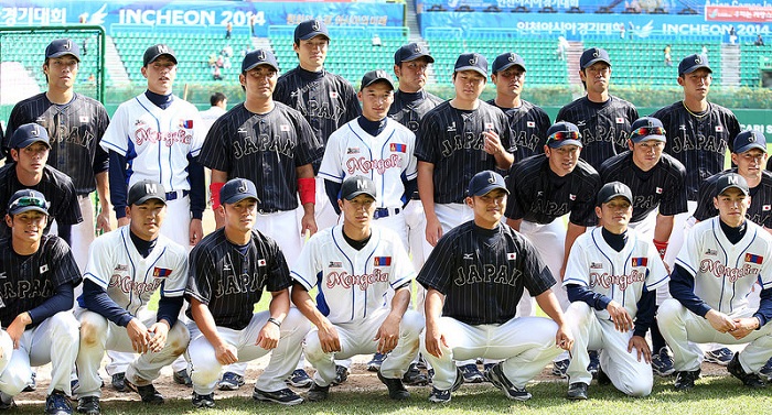 Athletes from Japan, in navy blue, and Mongolia pose for a group photograph after the game.