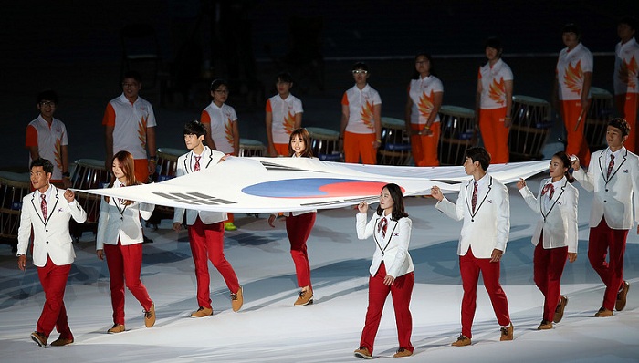 Eight Korean medalists enter the stadium holding the national flag to open the second part of the closing ceremony.