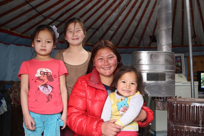 A family in Ulaanbaatar smiles as they use their G-Saver, an environmentally friendly heater for the home.