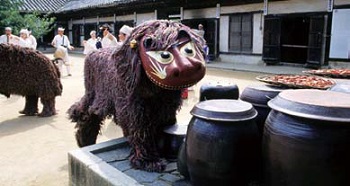(Top) A lion comes out of the kitchen holding a bowl made from a gourd in its mouth; (bottom) A lion steps up to the terrace where jars of fermenting pastes and vegetables are stored to cleanse it of evil spirits. 
