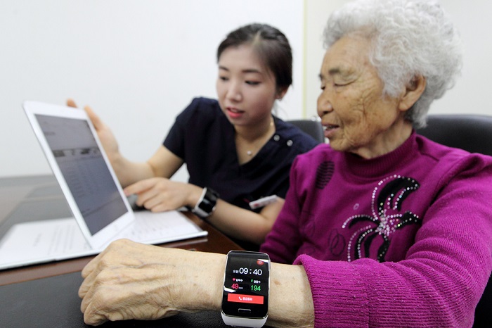 An elderly island resident learns how to use her smart watch, offered by KT.