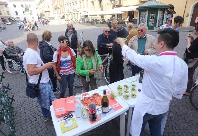 A group of visitors samples rice wrapped in greens offered by the Kimchi Bus.