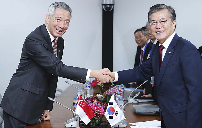 President Moon Jae-in (right) poses for a photo with Singaporean Prime Minister Lee Hsien Loong (left) at the Philippine International Convention Center in Manila on Nov. 14.