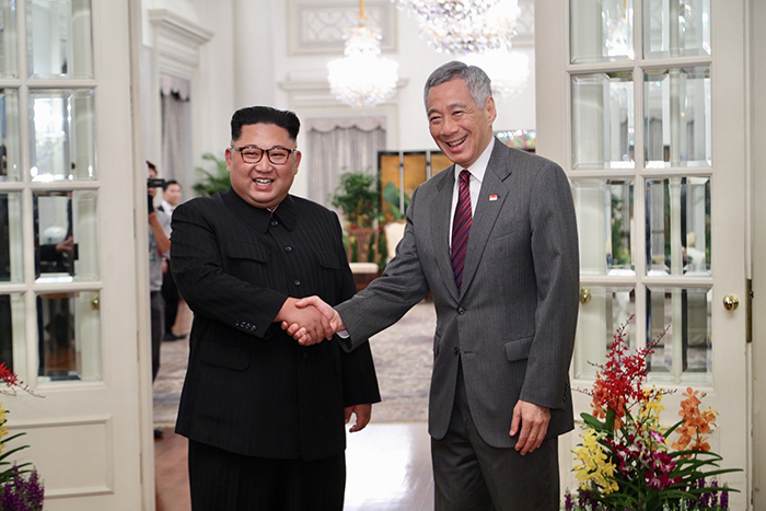Chairman of the State Affairs Commission Kim Jong-un (left) and Singaporean Prime Minister Lee Hsien Loong pose for a photo on June 10 at the Istana Presidential Palace in Singapore.