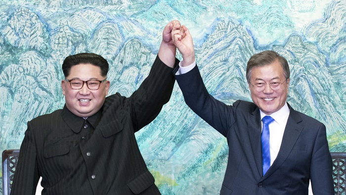 North Korean Chairman of the State Affairs Commission Kim Jong Un (left) and President Moon Jae-in hold up hands together at their first meeting held at the Peace House of the Panmunjeom Truce Village on April 27.