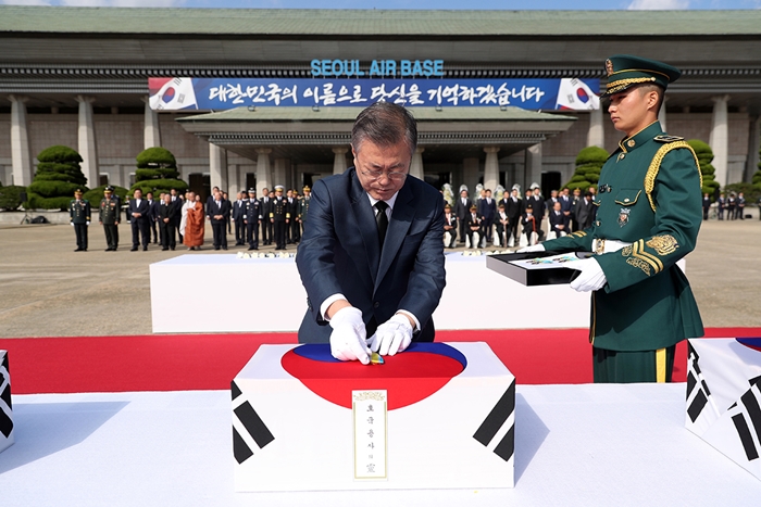 President Moon Jae-in confers a war medal on the soldier remains that returned home 68 years after the Korean War at a commemorative ceremony held at Seoul Airport on Oct. 1.