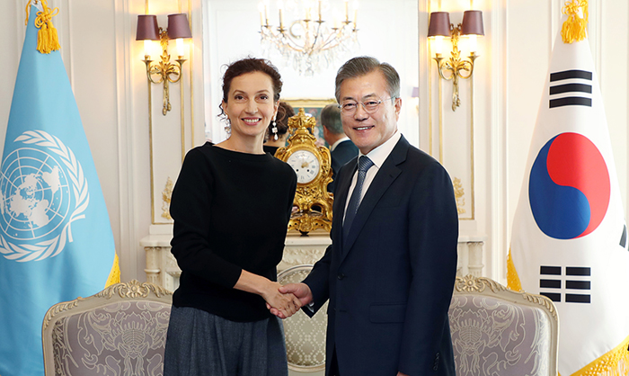 UNESCO Director-General Audrey Azoulay (left) and President Moon Jae-in shake hands before their meeting at the Hotel Plaza Athenee in Paris on Oct. 16.