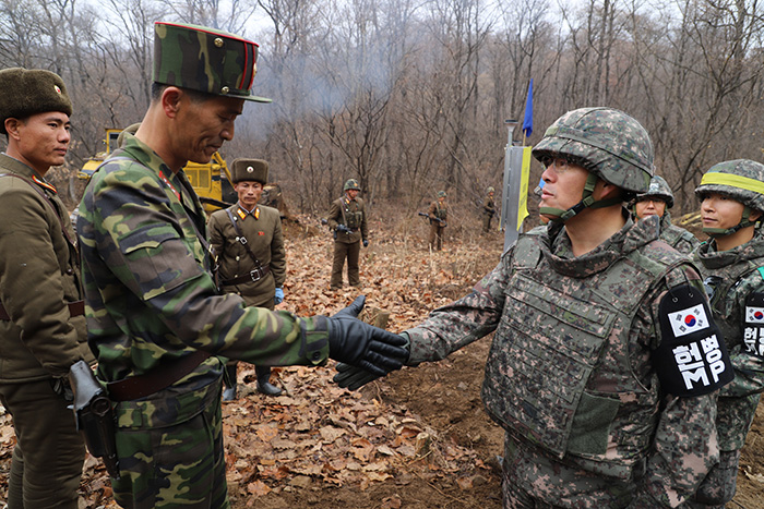 Soldiers from South and North Korea working on the road connection project meet at the Military Demarcation Line in Cheorwon, Gangwon-do Province in November. (Ministry of National Defense)