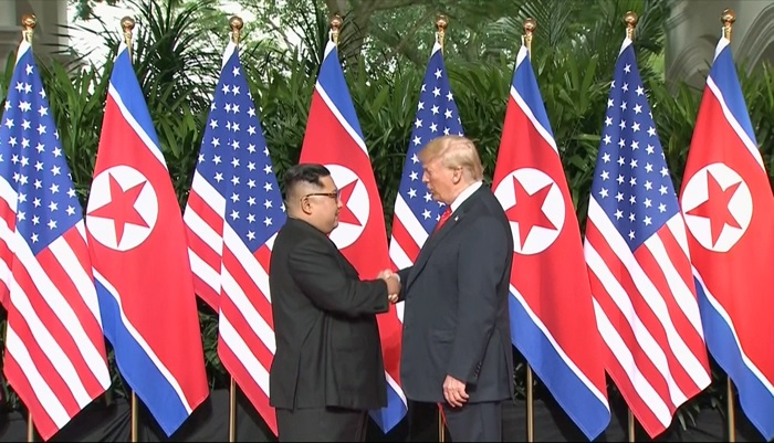 North Korean leader Kim Jong Un (left) and U.S. President Donald Trump on June 12, 2018, exchange a handshake before holding their summit at Capella Hotel in Sentosa, Singapore. (Yonhap News)