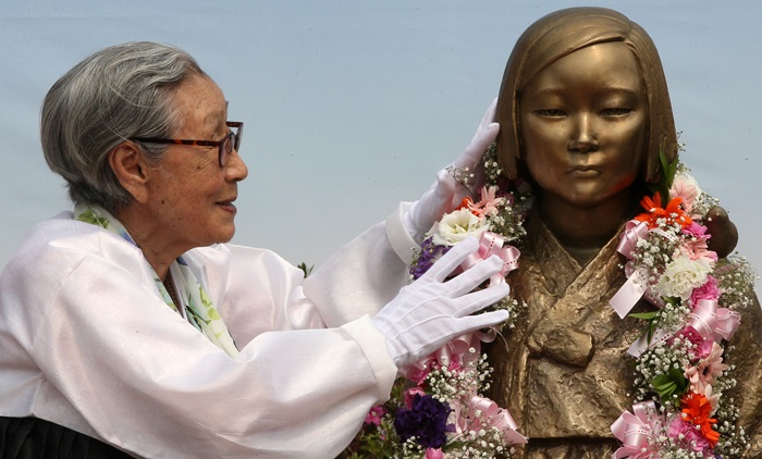 Kim Bok-dong in April 2014 touches the Statue of Peace, a memorial to victims of Japan’s wartime sexual slavery like Kim, at Seongnam City Hall’s Front Plaza in Seongnam, Gyeonggi-do Province. (Yonhap News)