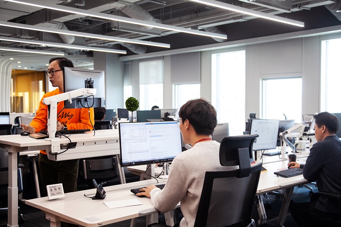 Employees in a 5G smart office can bring up saved data on their desktop monitors by connecting their smartphones to docking pads installed in each desk.
