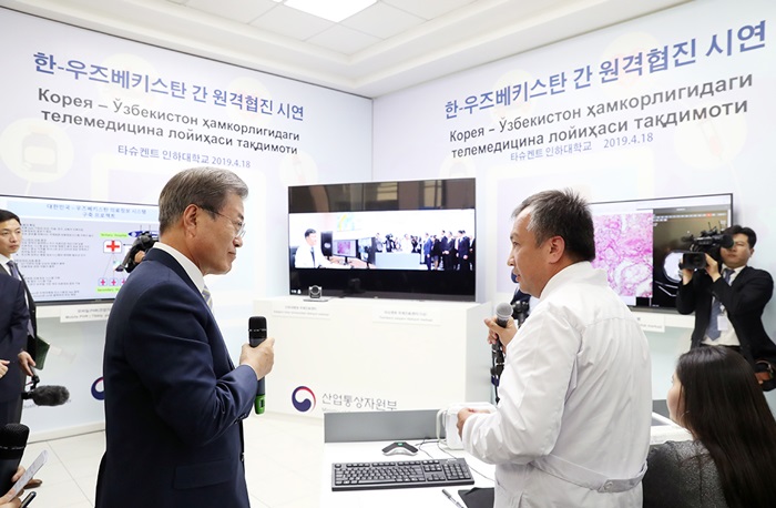 President Moon Jae-in (left) on April 19 listens to an explanation about joint telemedicine between Korean and Uzbek medical teams at Inha University’s campus in Tashkent, Uzbekistan. Inha University-Tashkent (IUT) opened in 2014 to allow the Uzbek government to acquire Korea’s human resource development system based on information and communications technology. Inha’s main campus in Incheon is also financing IUT’s establishment advisory and academic management. (Cheong Wa Dae)