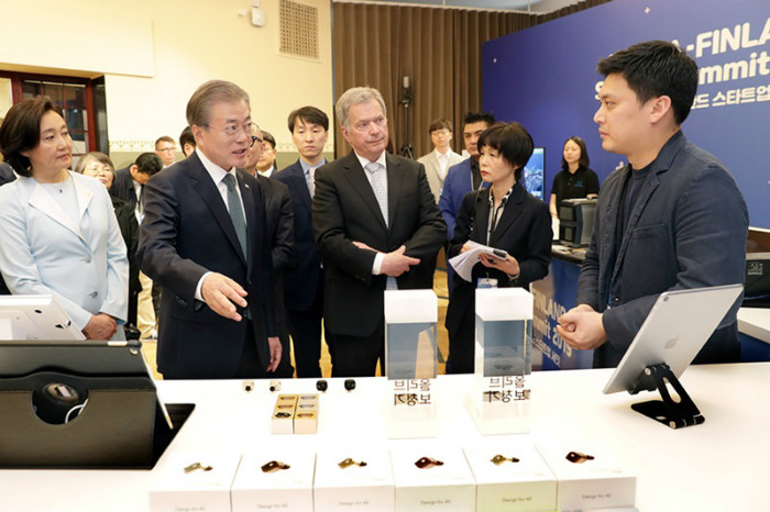 President Moon Jae-in (second from left), accompanied by Finnish President Sauli Niinisto, on June 11 speaks to a representative of a startup at the Korea-Finland Startup Showcase in Helsinki.