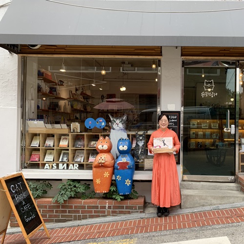 Schrödinger owner Kim Min-jung holds a book in front of her bookstore in Seoul’s Hyehwa-dong neighborhood.