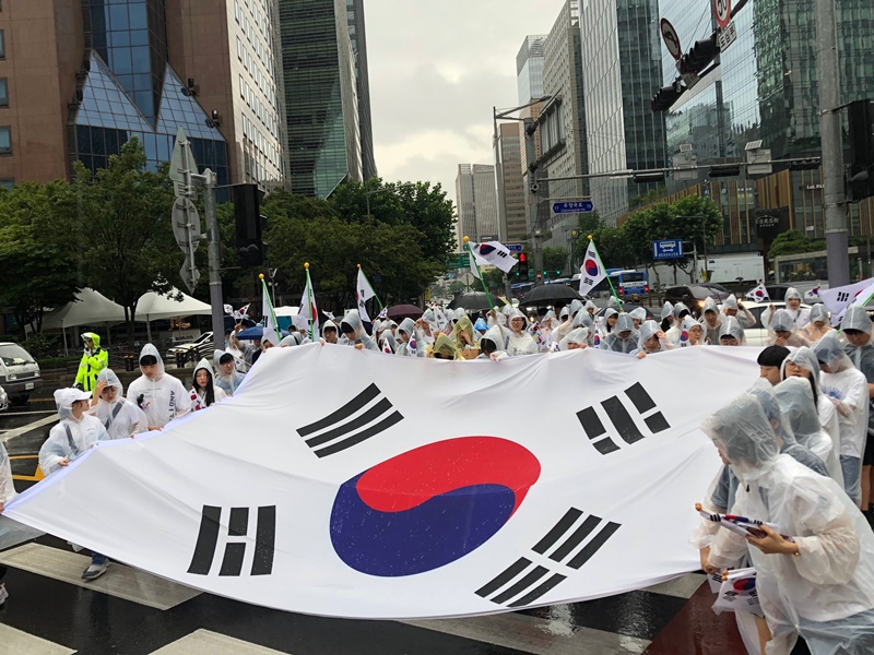 A host of events are held in Seoul on Aug. 15 to celebrate National Liberation Day. Despite the rain, 300 people held a large Taegukgi (national flag) and reenacted the independence march, shouting 