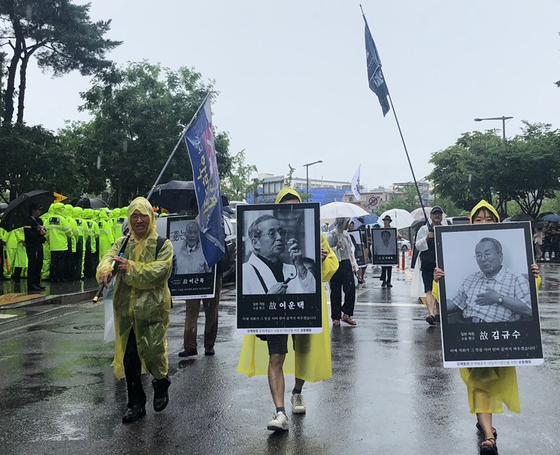 Despite torrential rain in the afternoon of Aug. 15, more people participated in marches in downtown Seoul. About 2,000 amassed at Seoul Plaza, with some holding photos of forced labor victims of Japanese colonialism, and demanded an apology from Japan. (Kim Minji)