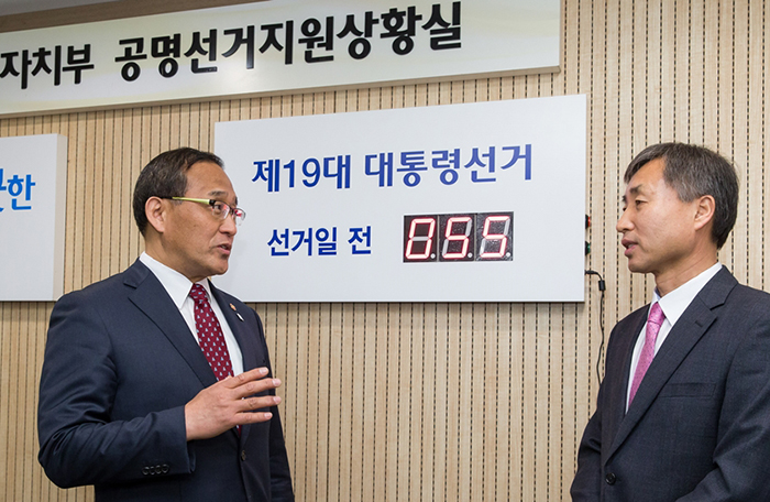 Minister of the Interior Hong Yun-sik (left) talks with Cho Hyunki, who is in charge of the Fair Election Support Office for the 19th Presidential Election, on March 15.