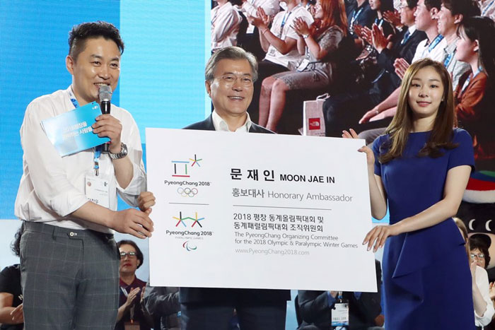 In a special event to mark 200 days until the PyeongChang 2018 Olympic and Paralympic Winter Games, President Moon Jae-in (center) receives an over-sized business card with his name on it, appointing him as a new honorary ambassador for the Winter Games. Kim Yuna (right) and Jung Chan-woo, both of whom are already honorary ambassadors for the Winter Games, hand him the card. The ceremony took place at Alpensia Resort in Pyeongchang, Gangwon-do Province, on July 24.