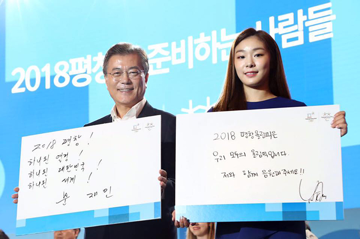 President Moon Jae-in (left) and figure skating champion Kim Yuna pose for a photo after the president accepted an offer to become an honorary ambassador for the PyeongChang 2018 Olympic and Paralympic Winter Games, at Alpensia Resort in Pyeongchang on July 24.