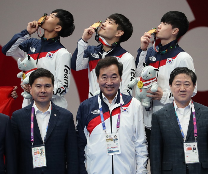 Korean taekwondo athletes Kang Wanjin, Han Yeonghun and Kim Seonho (back row, from left) hold up their gold medals after the Men's Team Poomsae Finals at the Asian Games 2018 Jakarta-Palembang. They pose for a commemorative photograph with Prime Minister Lee Nak-yon (front, center) at the Jakarta Convention Center (JCC) in Jakartaon Aug. 19. (Yonhap News)