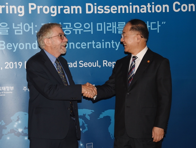 Minister of Finance and Economy Minister Hong Nam-ki (right) on Sept. 9 shakes hands with Nobel laureate economist Paul Krugman at a conference in Seoul on sharing the results of the government-run Knowledge Sharing Program of Korea. (Ministry of Economy and Finance)