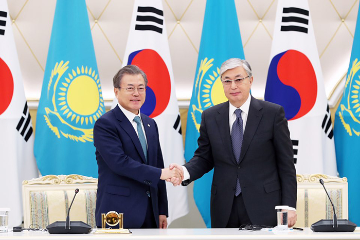 President Moon Jae-in (left) on April 22 shakes hands with Kazakh President Kassym Jomart Tokayev at a signing ceremony after their summit.