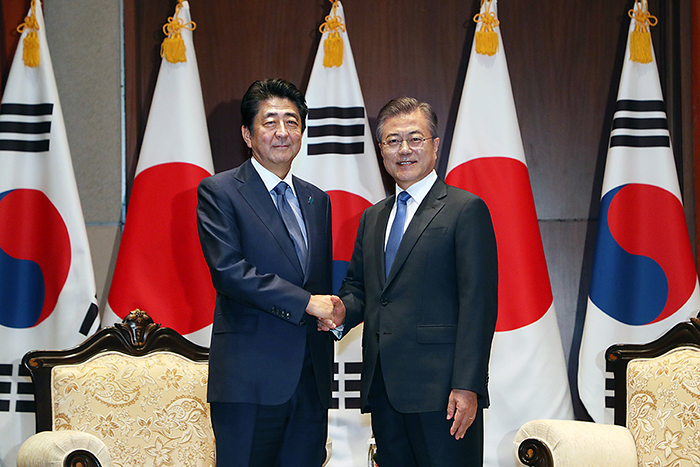 Japanese Prime Minister Shinzo Abe (left) and President Moon Jae-in shake hands before their summit in New York on Sept. 25. (Cheong Wa Dae)