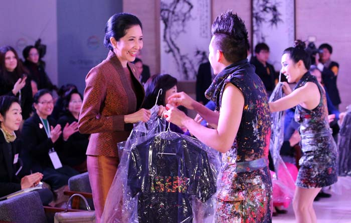 Naraporn Chan-ocha (left), wife of Thai Prime Minister Prayut Chan-ocha, is given a shirt on which the word “ASEAN” has been painted by the artist at the Busan Museum of Art on December 12.