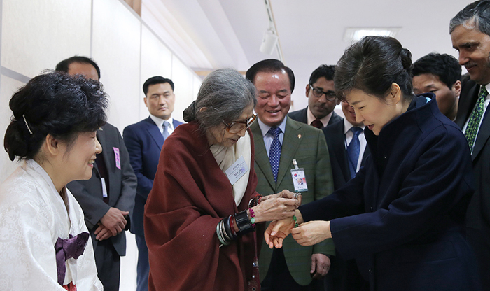 Tara Gandhi (center), the granddaughter of Mahatma Gandhi, puts a handcrafted bracelet around the wrist of President Park Geun-hye (right) at the Korean Handicraft Exhibition at the Red Fort in Delhi, India, on January 17. (Photo: Jeon Han)