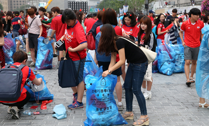 Fans of Team Korea clean up garbage in Gwangwhamun Square in downtown Seoul after the match against Algeria on the morning of June 23. (photo: Jeon Han) 