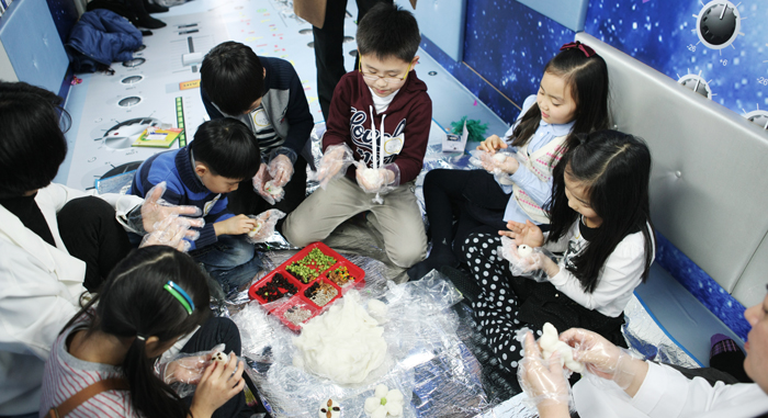 Children make tteok (rice cake) as part of a cultural arts program in the Moving Arts Bus (photo courtesy of MCST).