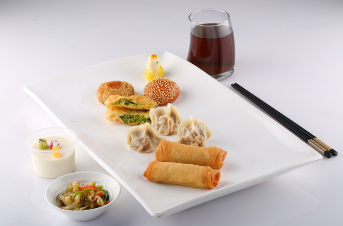 Boiled and fried dumplings with spring rolls are set with a dessert from China.