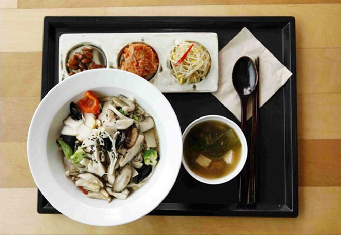 Rice is topped with mushrooms and vegetables. This dish will be served by the Buddhist monk Daean.