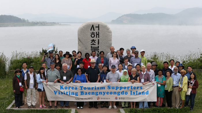 The travel group poses for a photo at the memorial site (photo: Jeon Han).