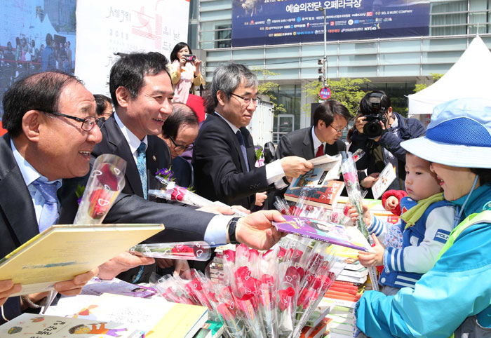 Participants at the World Book Day ceremony give books and roses to citizens at Cheonggyecheon Stream, Seoul.