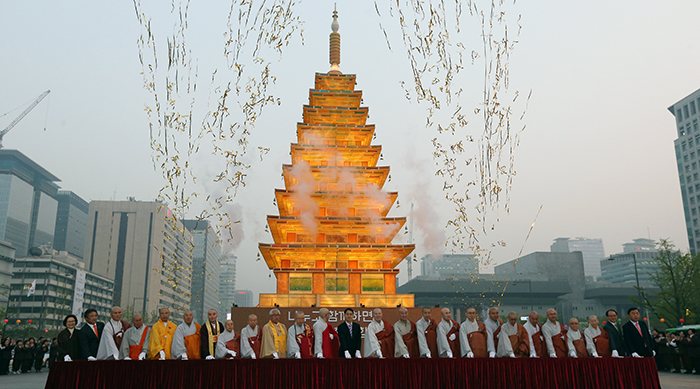 Buddhist monks light the stone pagoda-shaped lantern in Gwanghwamun Square on April 16. (photo: Jeon Han)