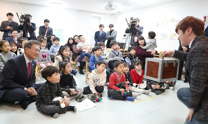 President Moon Jae-in enjoys a magic show with young audience members at a childcare center in Dobong-gu District, Seoul, on Jan. 24. (Cheong Wa Dae Facebook)