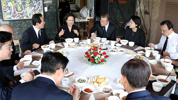 President Moon Jae-in (third from right), first lady Kim Jung-sook (second from right) and other dignitaries share some <i>yukgaejang</i> spicy beef soup for lunch, prepared by Kwon Yang-sook (second from left), Roh Moo-hyun's widow, prior to the memorial service for the passing of former President Roh, in Bongha Maeul Village, Gimhae City, Gyeongsangnam-do Province, on May 23.